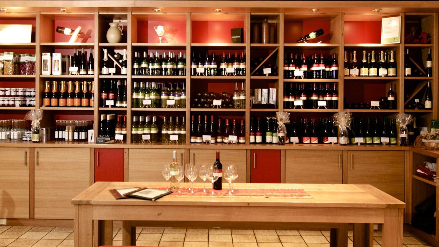 Weinrestaurant & Vinothek Kaisergarten - im Vordergrund ein Tisch zur Verkostung und im Hintergrund ein Weinregal mit Weinen des Weinguts Biegler & Brand