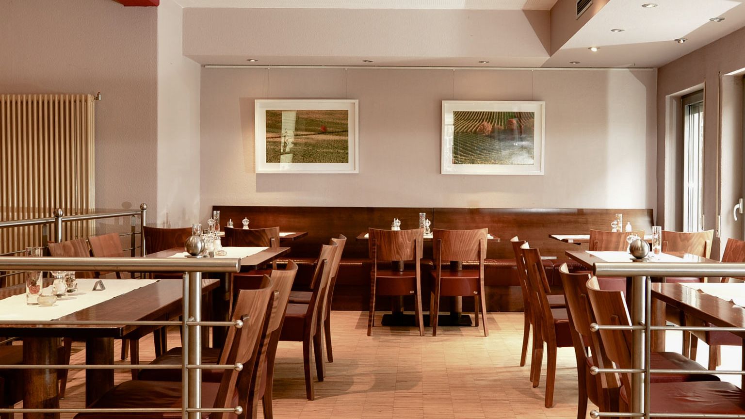 Blick auf eingedeckte Tische auf der etwas erhoehten Empore im Weinrestaurant & Vinothek Kaisergarten in Alzey