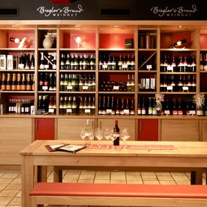 Weinrestaurant & Vinothek Kaisergarten - im Vordergrund ein Tisch zur Verkostung und im Hintergrund ein Weinregal mit Weinen des Weinguts Biegler & Brand